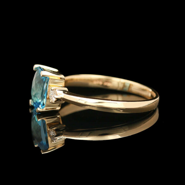 a ring with an aqua blue stone and two diamonds