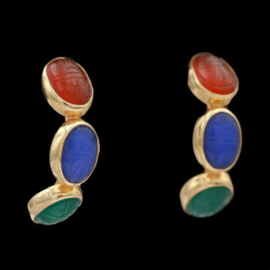 a pair of earrings with red, blue and green stones