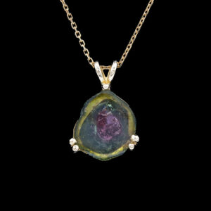 a necklace with a green and yellow stone on it