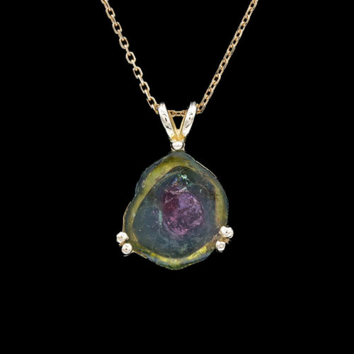 a necklace with a green and yellow stone on it
