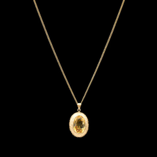 a gold necklace with an oval shaped pendant