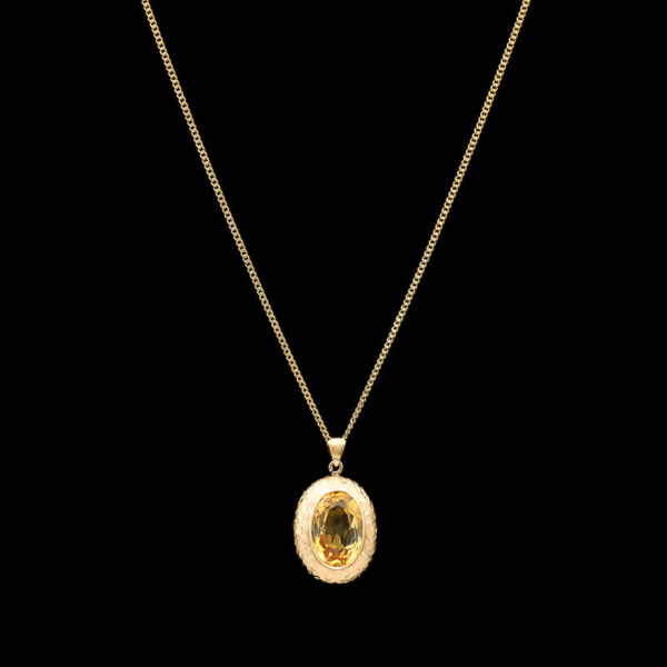 a gold necklace with an oval shaped pendant