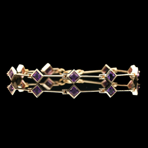 a gold bracelet with purple stones on it