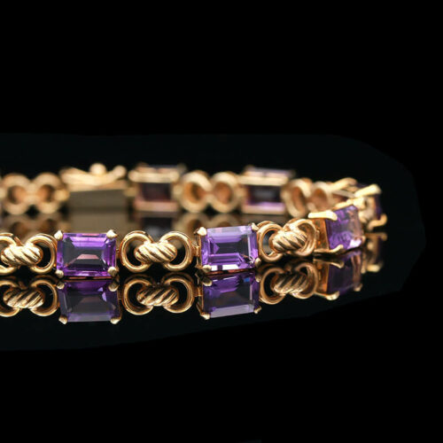 a gold bracelet with amethorate and purple stones