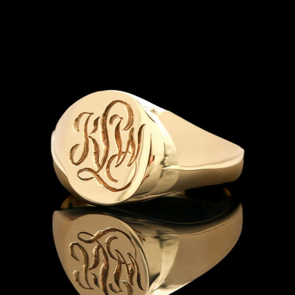 a gold ring with two initials on it