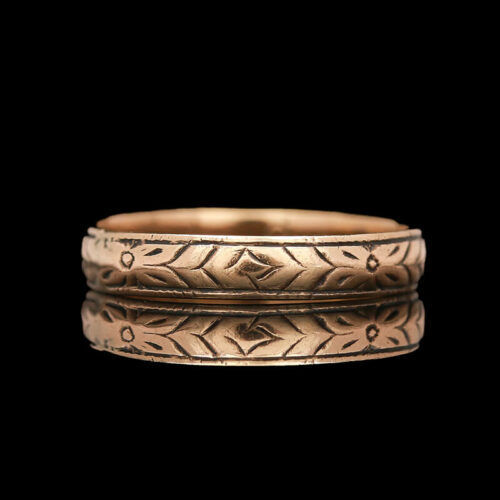 two gold wedding bands on a black background