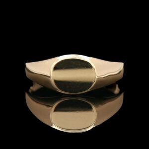 a gold ring sitting on top of a reflective surface