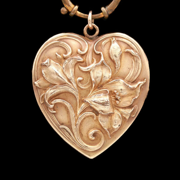 a heart shaped pendant with flowers on it