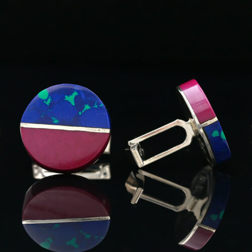 a pair of cufflinks with blue, pink and green designs