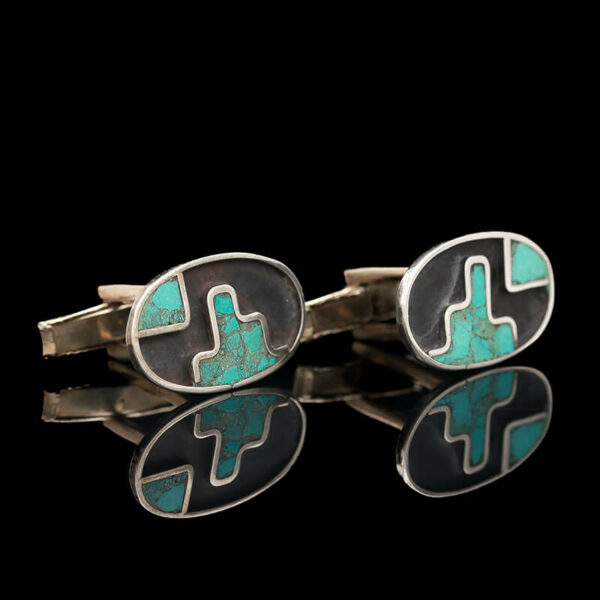 a pair of cufflinks with turquoise and black stones