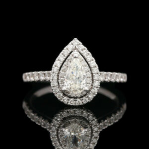 a pear shaped diamond engagement ring on a reflective surface