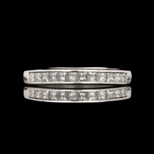 a diamond set wedding ring on a black background
