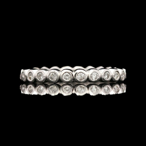 a white gold and diamond ring on a black background