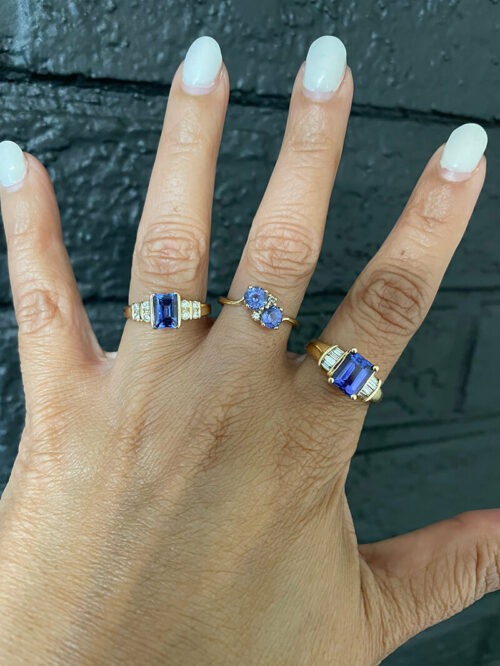 a woman's hand with three different rings on it
