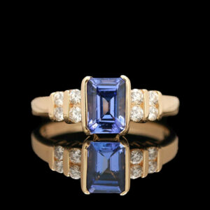 a tan gold ring with a blue sapphire and diamonds