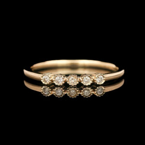 a gold ring with five diamonds on it