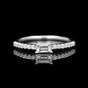 a white gold ring with three baguettes and diamonds