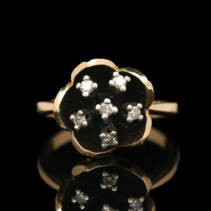 a black and white diamond ring on a reflective surface