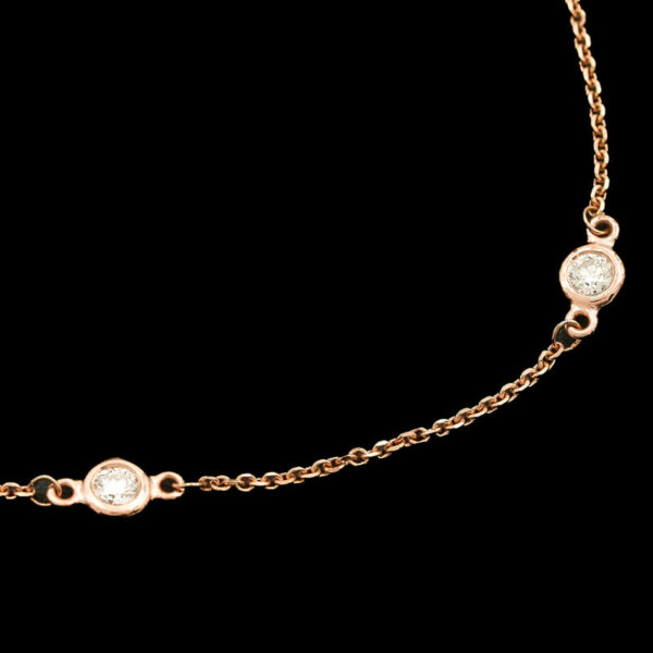 a gold chain with two round charms on it