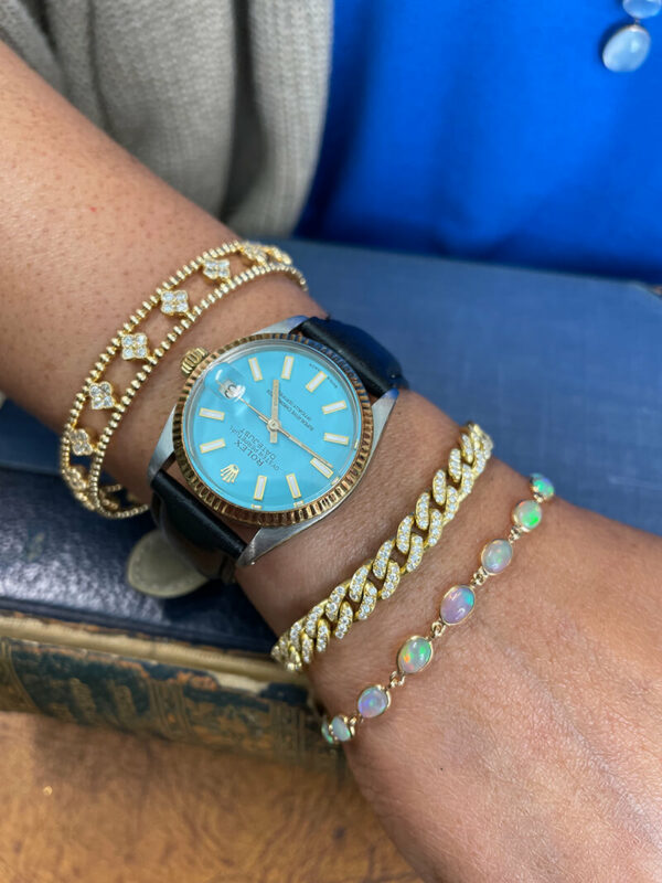 a woman's wrist with bracelets and a watch