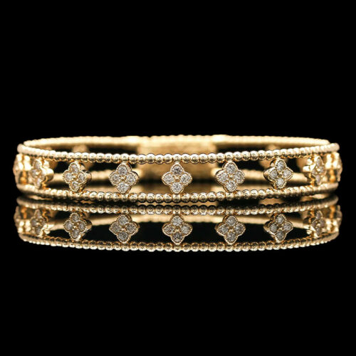 a stack of gold and diamond bracelets