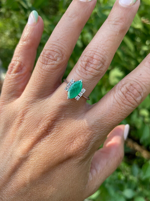 a woman's hand with a green ring on it