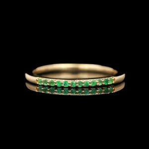 a gold ring with green stones on it
