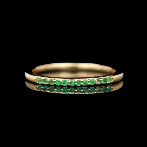 a gold ring with green stones on it