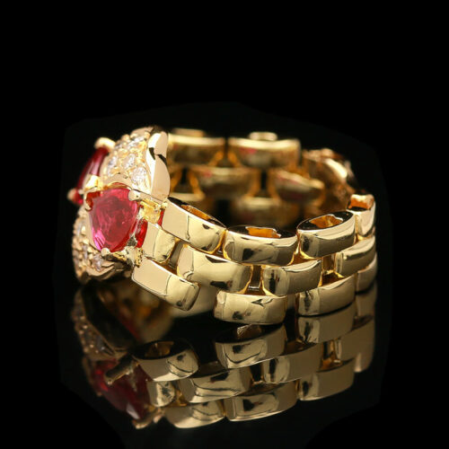 a gold bracelet with a red heart on it