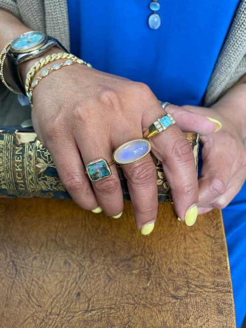 a woman with yellow nails and rings on her hand