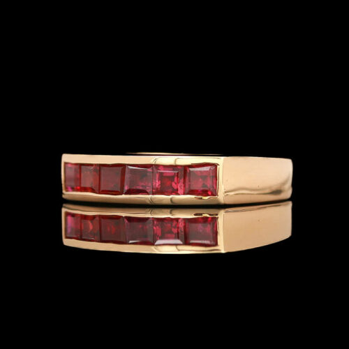 two gold rings with red stones on them