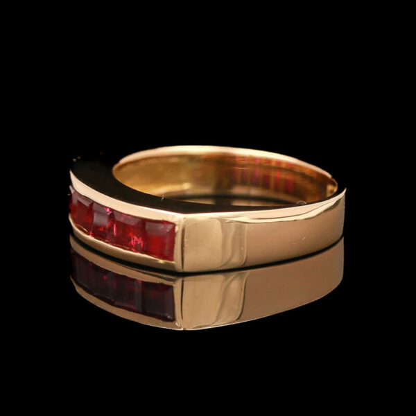 a gold ring with two red stones on it