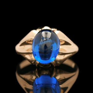a gold ring with a blue stone in it