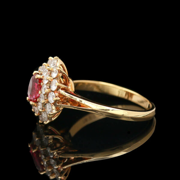 a gold ring with an oval shaped ruby and white diamonds