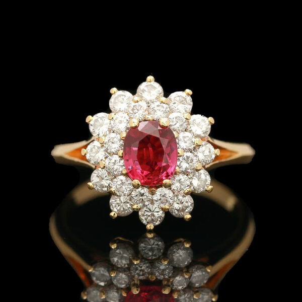 a red and white diamond ring on a black surface