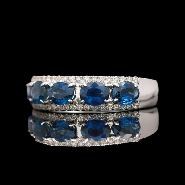 a blue and white diamond ring on a reflective surface