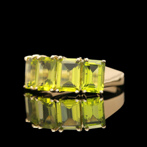 a yellow ring with four square cut stones