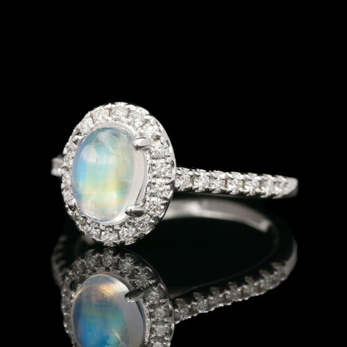a ring with a rainbow colored stone surrounded by diamonds