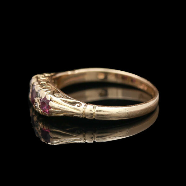 a gold ring with pink stones on it