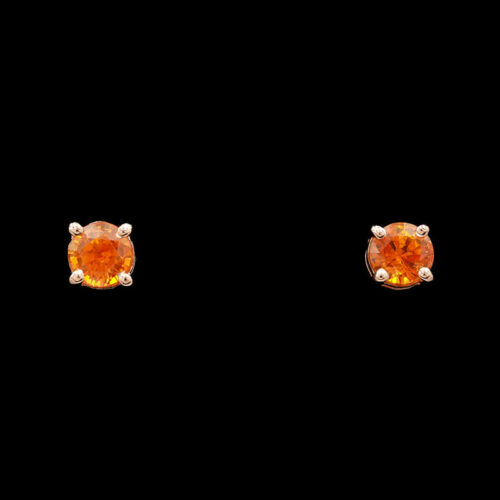 a pair of earrings with an orange stone