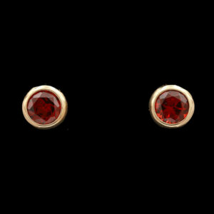 a pair of red earrings on a black background