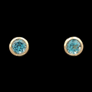 a pair of gold earrings with blue stones