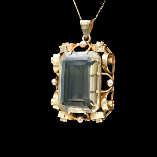 a pendant with an aqua green stone surrounded by pearls