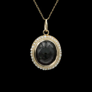 a necklace with a black stone and pearls