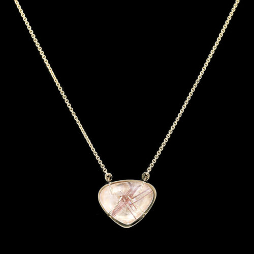 a necklace with a pink stone in the shape of a heart
