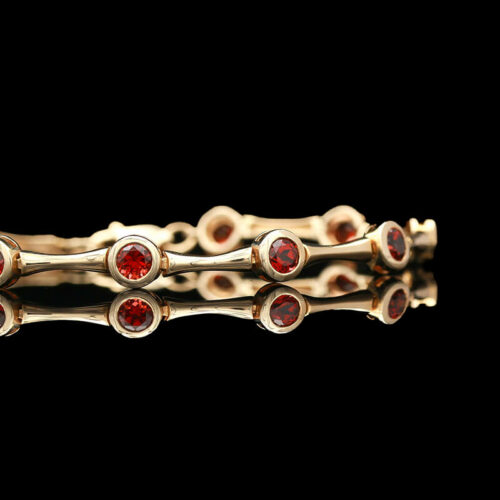 a close up of a gold ring with red stones