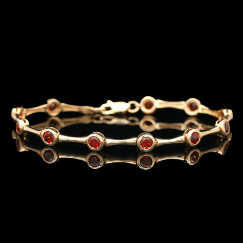 a gold bracelet with red stones on it