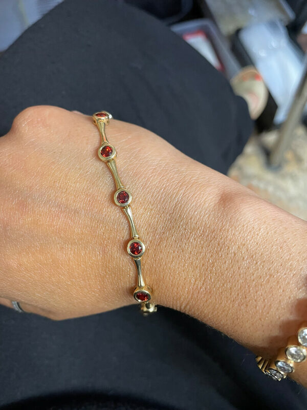 a woman's arm with a gold bracelet on it