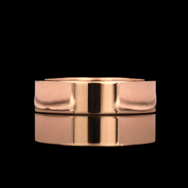 a rose gold wedding ring on a black background
