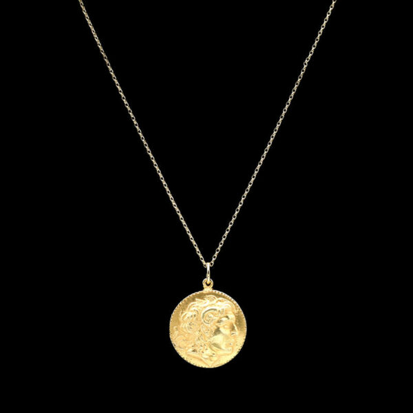 a gold coin necklace on a black background